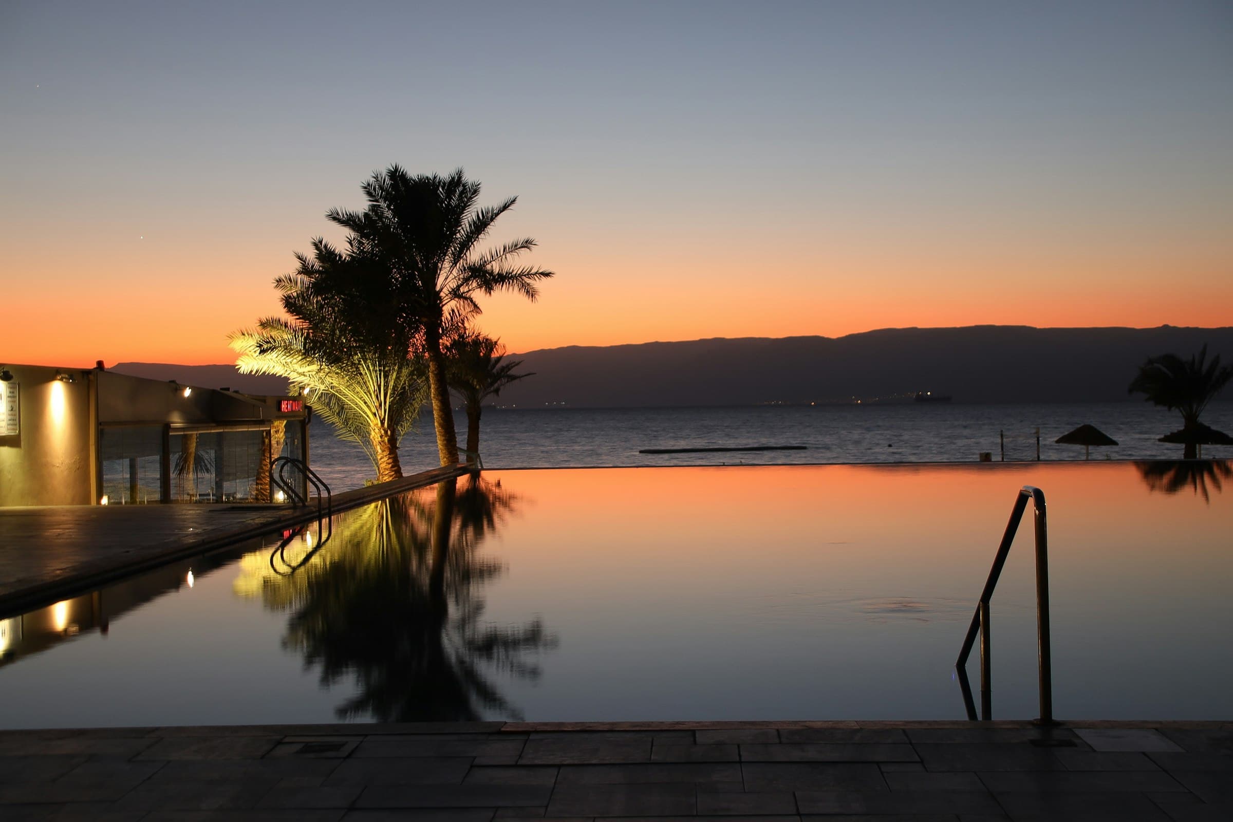 An infinity pool meeting the sea at sunset